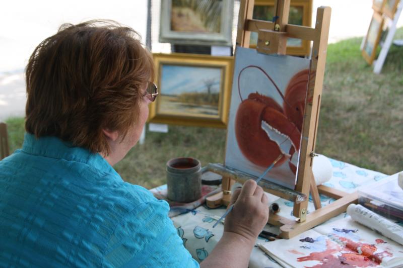 Mary Kay Ebersold works on a painting of a lobster outside of the Wareham-Bourne Art Association's 54th Annual Summer Show held on Saturday. BY MATTHEW BERNAT